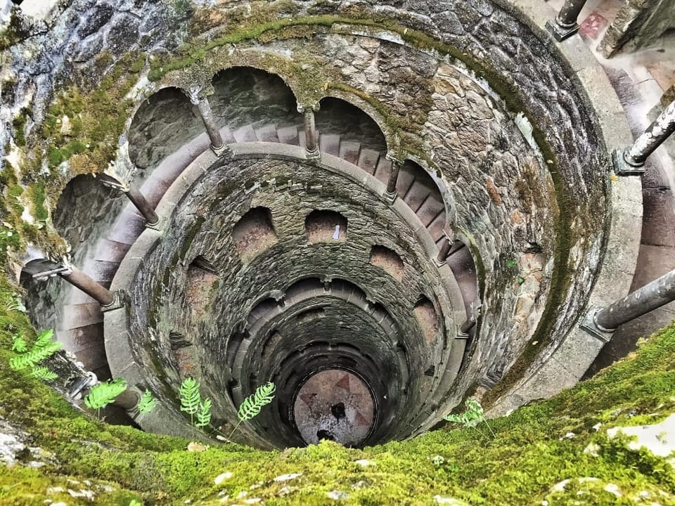 a stone well descends more than 9 floors, below ground, with stairwells descending in a spiral